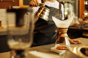 A woman pouring hot water into a coffee filter