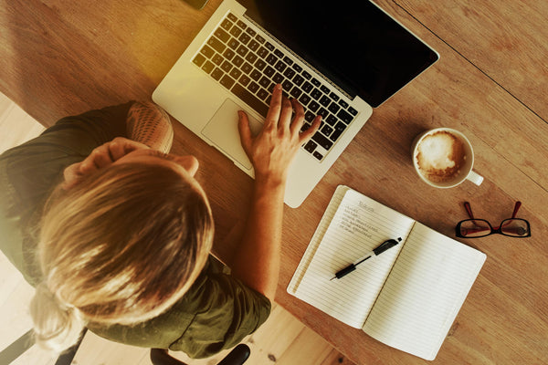 A woman working on a laptop in a coffee shop